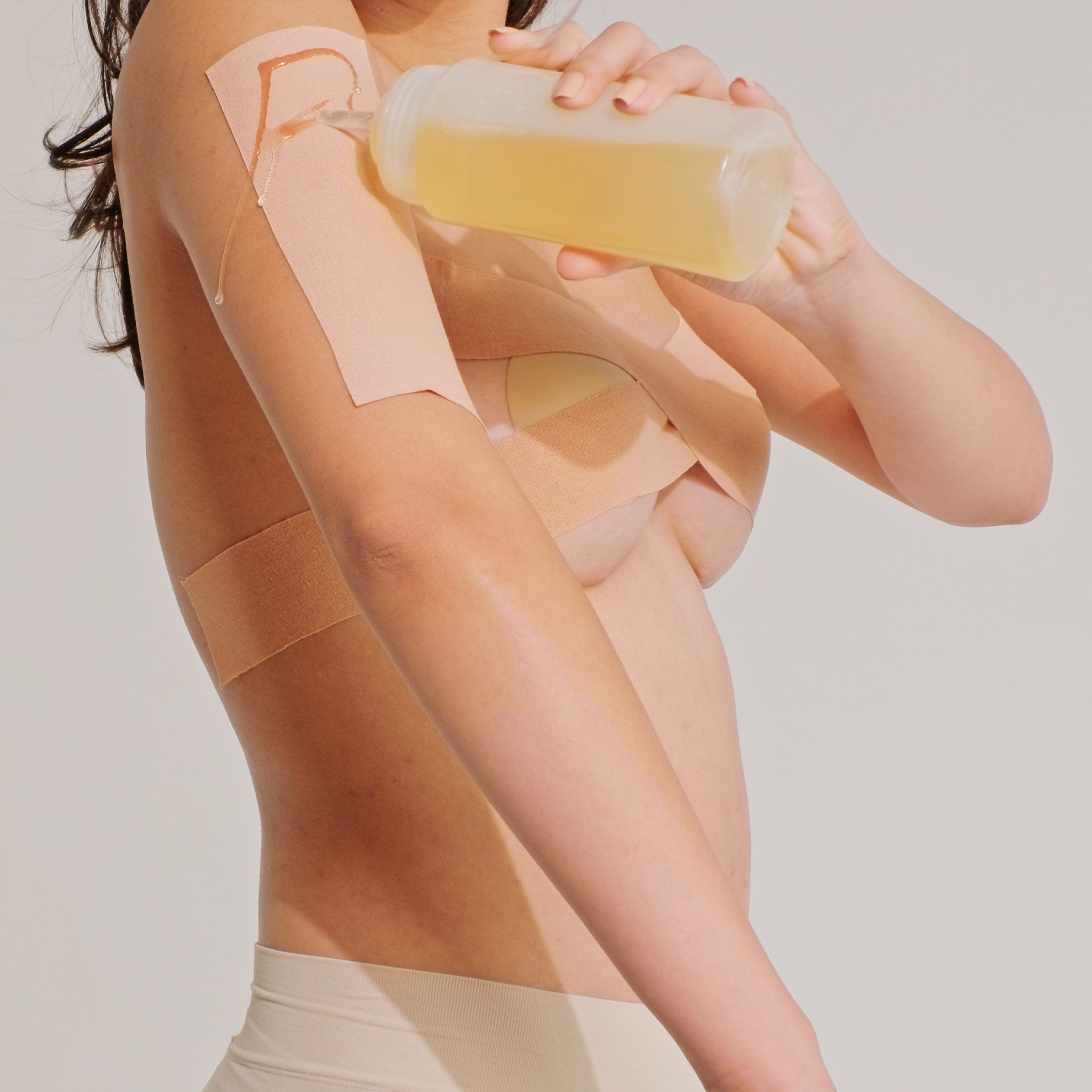 Model applying oil on Nippetals GlamTape before removal to ensure gentle and smooth detachment