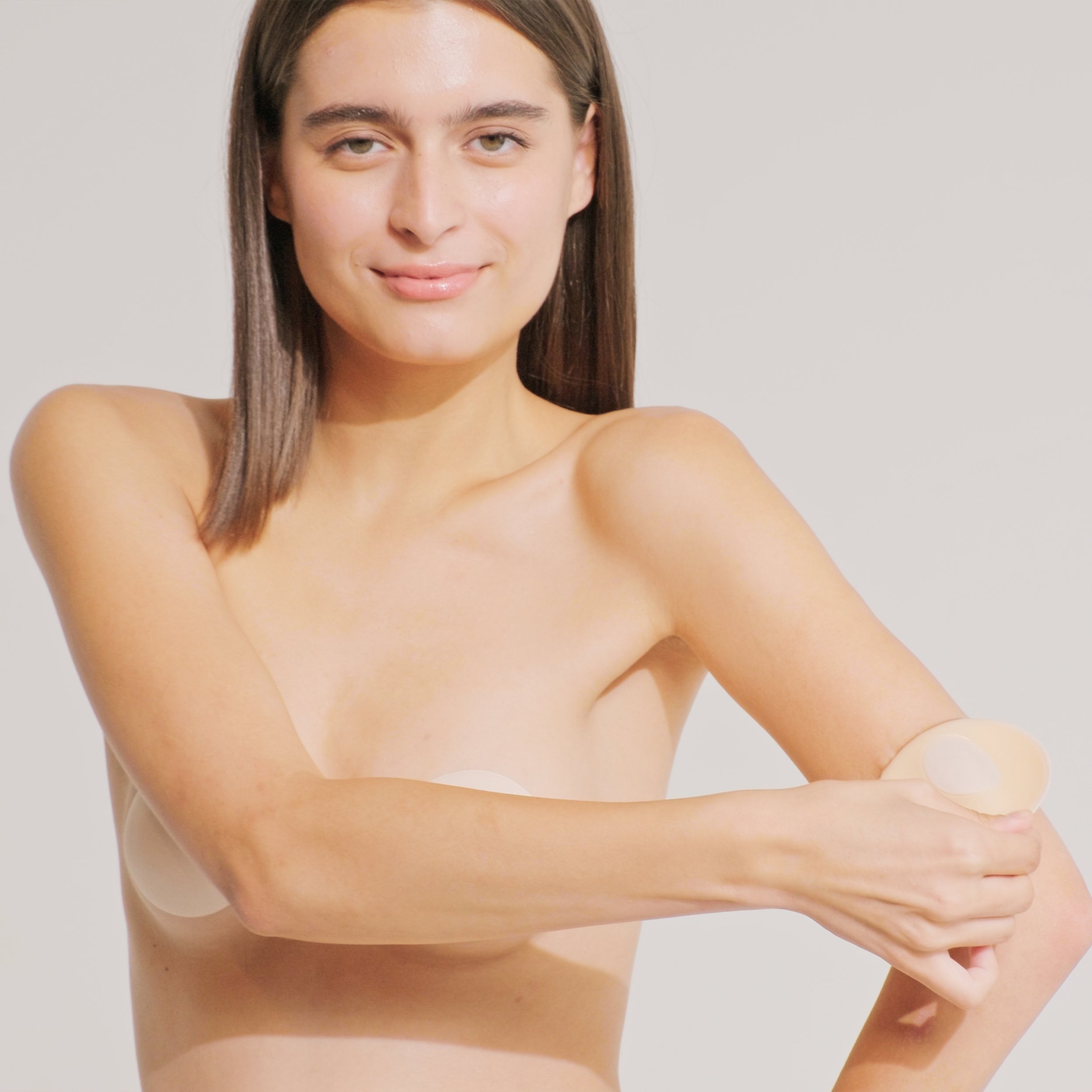 Model peeling the Nippetals MicroBra fabric nipple cover from edge to center for easy and irritation-free removal