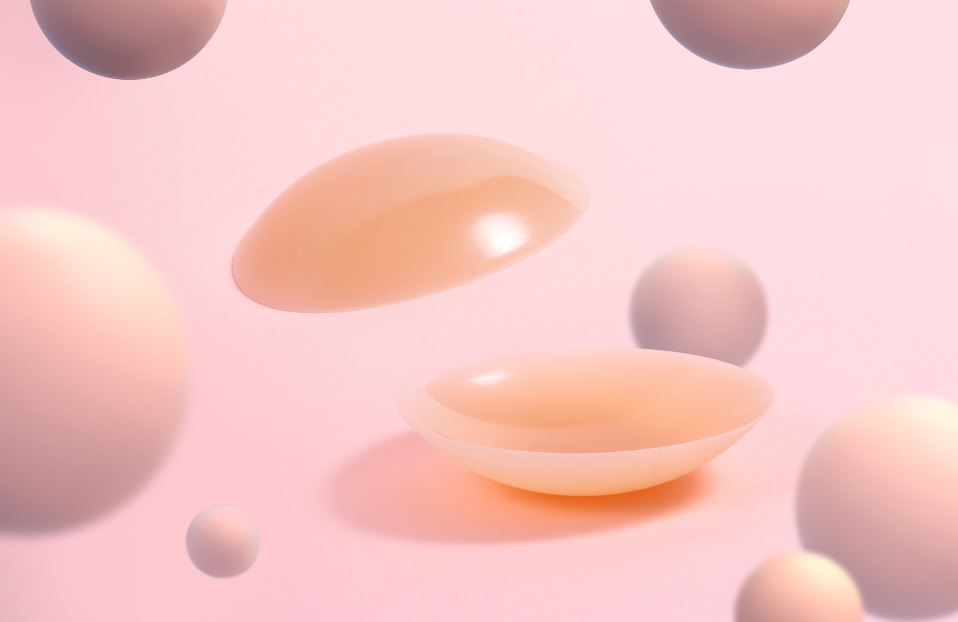 A pair of Nippetals silicone nipple covers, displayed on a soft pink background, highlighting its comfortable design for active concealment