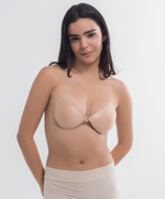 Woman wearing a beige strapless bra against a white background