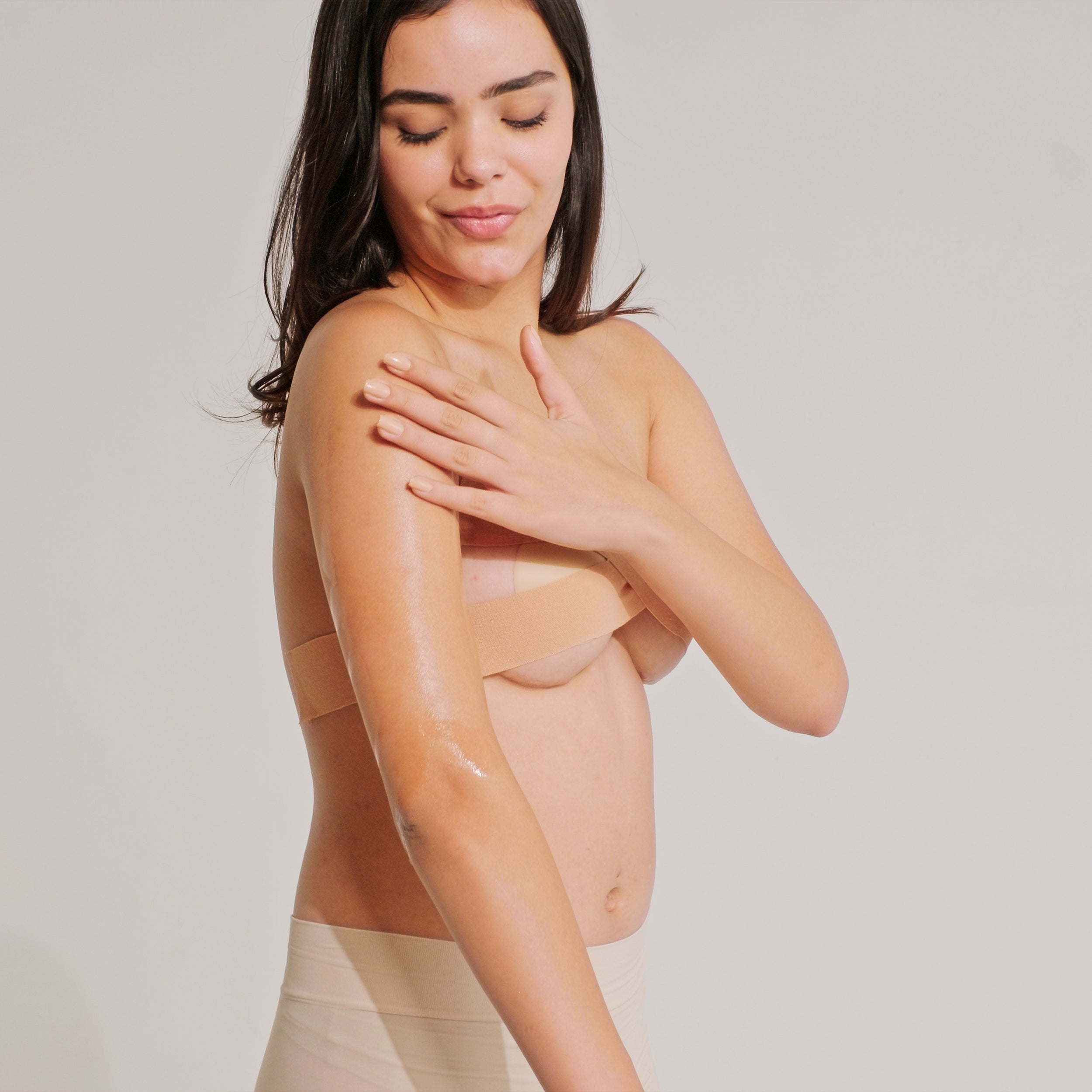 Model posing confidently after removing the boob tape, showcasing smooth and natural skin